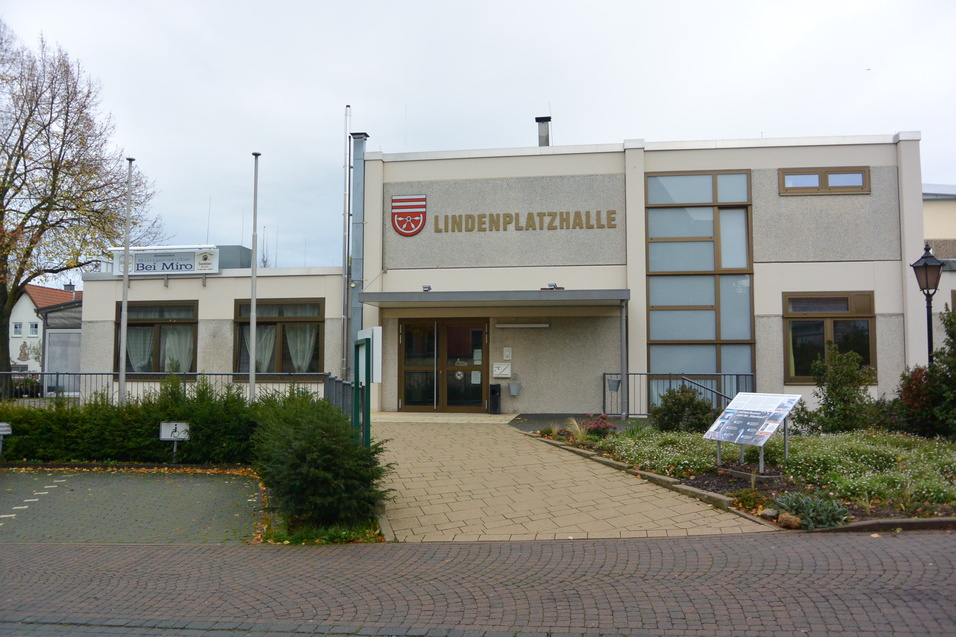 Fassade der Lindenplatzhalle mit Eingang, gro&szlig;en Fenstern und park&auml;hnlicher Umgebung.